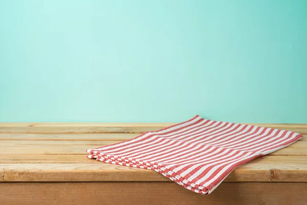 Tavolo in legno vuoto con tovaglia su sfondo blu — Foto Stock
