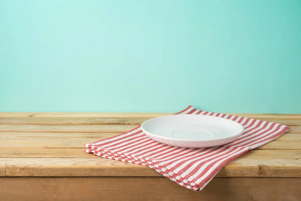 파란 반 그 랑 위에 빈 접시와 식탁보가 놓인 나무 탁자 — 스톡 사진