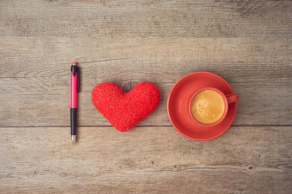 Love for coffee concept. Coffee cup, heart shape and pen on wood — Stock Photo, Image