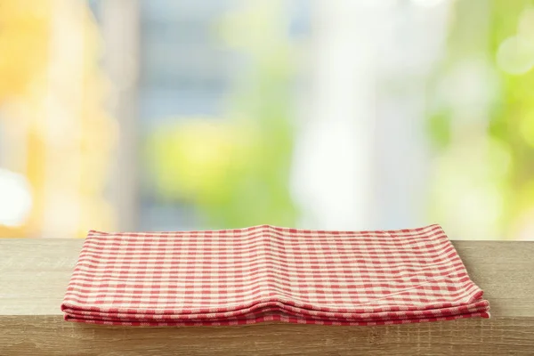 Empty wooden table with tablecloth over abstract bokeh backgroun — Stock Photo, Image