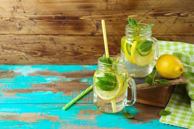 Limon, salatalık ve nane yapraklarıyla doldurulmuş su, ahşap arka planda. Detoks ve sağlıklı yaşam tarzı kavramı.