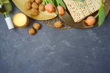 Yahudi bayramı bayramı kutlaması konsepti, sofrada yemek tabağı, matza ve lale çiçekleri. Pesach geçmişi. Yukarıdan üst görünüm.