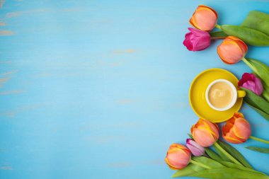 Kahve fincanı ve ahşap arka planda güzel lale çiçekleriyle anneler günü konseptiniz kutlu olsun. Yukarıdan üst görünüm