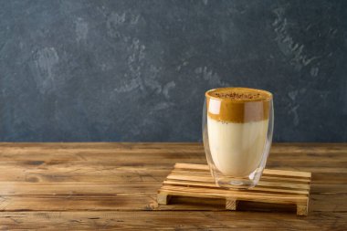 Dalgona kahvesi ya da ahşap masada sütlü kremalı kahve.