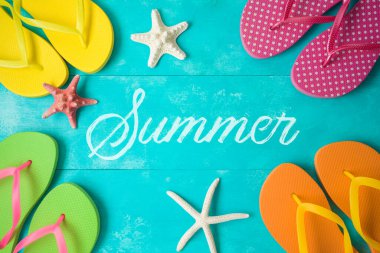 Mavi tahta üzerinde parmak arası terliklerle yaz arkaplanı