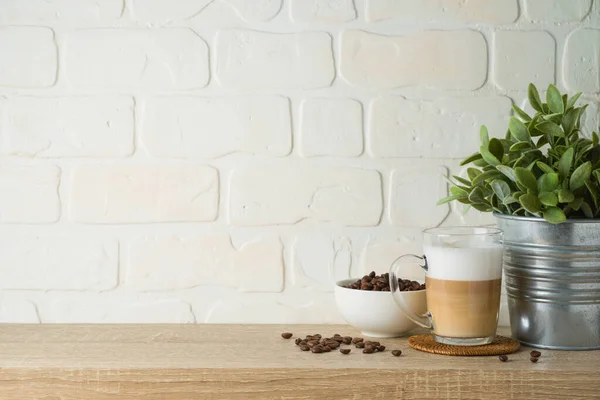 Kitchen background with coffee cup and plant on wooden shelf