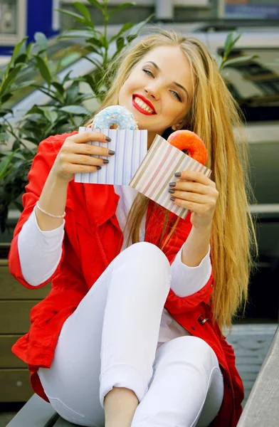 Giovane donna bionda con ciambelle in mano — Foto Stock