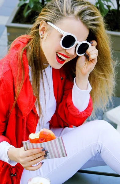 Улыбающаяся женщина с укушенным пончиком — стоковое фото