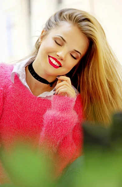 Привлекательная молодая женщина в розовом свитере — стоковое фото