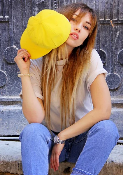 Модная женщина позирует в желтой кепке — стоковое фото