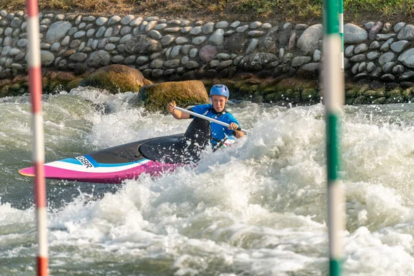 Great Britain Canoe Slalom athlete training on white water with poles in the foreground