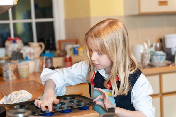 Hübsche junge blonde Mädchen bereitet sich auf Backen in einer chaotischen Küche — Stockfoto