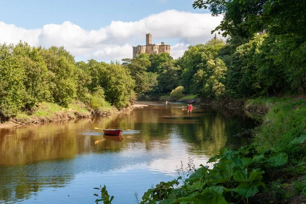 Roeiboten op de rivier de Coquet met Warkworth Castle op de achtergrond — Stockfoto