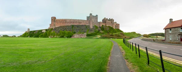 Panoramiczny widok na zamek Bamburgh oglądane od wsi zieleni i krykieta ziemi — Zdjęcie stockowe