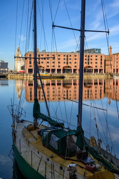 Tall shot of the Albert Dock in Liverpool through the rigging of a small boat moored at the side — Stock Photo, Image