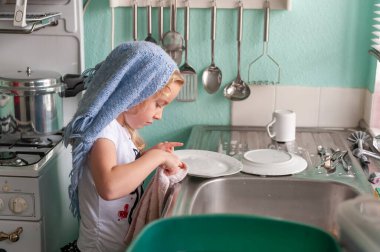 Güzel genç kız lavaboda bulaşıkları yıkıyor.
