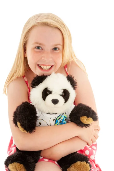 Close up of very happy beautiful young blonde girl with a big smile cuddling her teddy bear and making eye contact. Isolated on white studio background — Stock Photo, Image