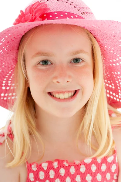 Close up of beautiful young blonde girl with a big smile wearing a big pink floppy hat and looking directly at the camera. Isolated on white studio background — Stock Photo, Image