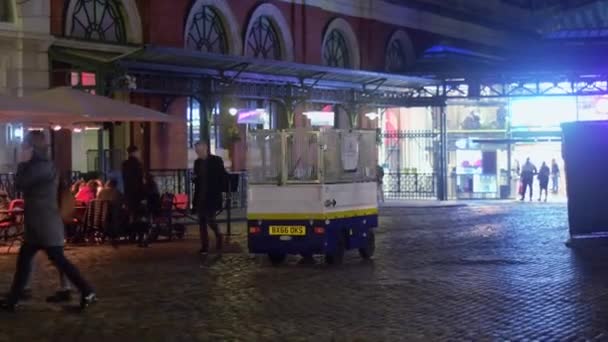 ロンドン 10月23 2019 夜にコヴェントガーデンのロイヤルオペラハウスに向かってケーブルを渡ってカートを引く街の清掃員 — ストック動画