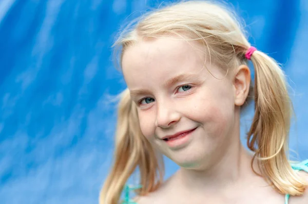 Pretty young blonde girl with pigtails smiling at the camera — Stock Photo, Image