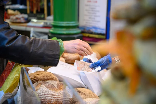 Un cliente que acaba de pagar por panes en un puesto de pan en Borough Market, Londres — Foto de Stock