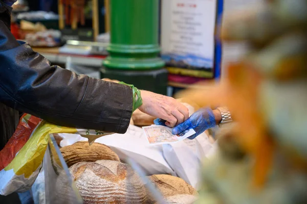 Un cliente que paga panes en un puesto de pan en Borough Market, Londres — Foto de Stock