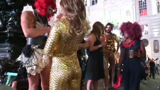 ロンドン 9月14 2019 ピカデリーサーカスで夜にクロスドレッサーをパーティーする華やかな服装のグループ ユーロキューピッド像のベースで 有名なデジタル看板によって照らされた — ストック動画
