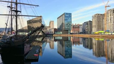 Liverpool 'daki Canning Rıhtımı' nı çevreleyen uzun gemi ve modern ofis binaları. Güneşli bir günde suda güzel yansımalar.