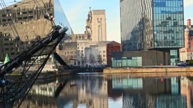 Liverpool 'daki Canning Rıhtımı' nı çevreleyen modern ofis binalarından uzaklaşarak sudaki yansımaları ve kenarda demirlemiş uzun bir gemiyi ortaya çıkar..