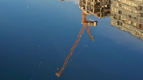 Желтый Строительный Кран Офисные Здания Отражаются Глубокой Голубой Воде Солнечный — стоковое видео