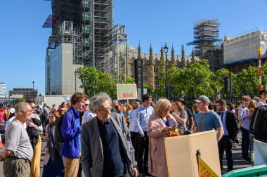 İklim Değişikliği protestocuları Parlamento Meydanı, Londra 'da gösteri yapıyor ve arkasında Parlamento Binaları var