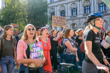 İklim Değişikliği protestocuları Whitehall, Londra 'da düzenlenen Soykırım İsyanı protesto yürüyüşünde slogan ve pankart tutuyorlar