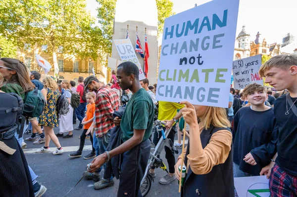 Протестующий против изменения климата с самодельным плакатом протеста мимо Кенотафа на Уайтхолле, Лондон на марше Восстания Вымирания — стоковое фото