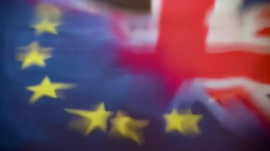 Uk Union Jack ve Avrupa Birliği bayrakları orta kısımda yavaş su sıçramasına yansıdı. Bozulmuş İngiliz Bayrağı 'nın kırmızı, beyaz ve mavi renkleri ve çarpık Eu bayrağının yıldızları görülebilir..