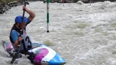 BRATISLAVA, SLOVAKIA - CIRCA  AUGUST, 2017: SLOW MOTION: Slalom Kayak paddler crossing a V-Wave and practising up stream gates in a K1 kayak