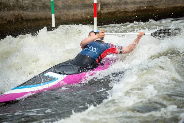 GB Canoe Slalom Athlete ducking under a slalom pole while negotiating an upstream gate in white water. Women\'s C1W class