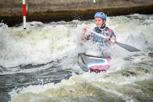 GB Каное Слалом Спортсменка з білою водою розбризкує навколо неї, коли вона перетинає хвилю. Жіночий клас C1W — стокове фото