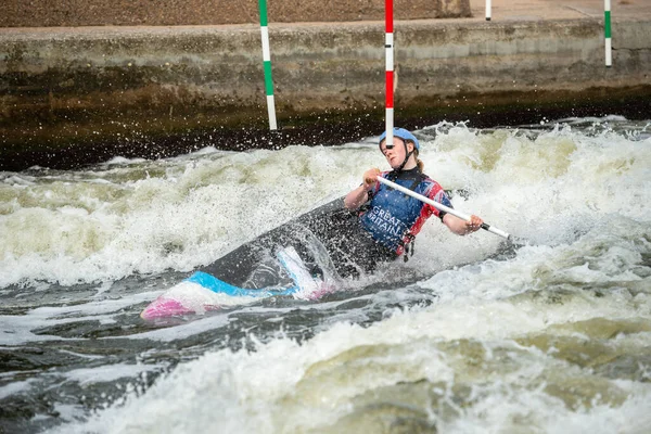 GB Canoe Slalom Athlete in the women\'s C1W class stretching to get around the pole of a slalom gate on white water