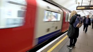 Londra - 26 Eylül 2019: Londra metro treni platforma ulaşırken akıllı telefon kullanan kadın