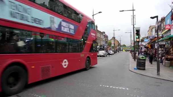 2019年9月30日 Zoom 一辆红色双层伦敦巴士沿着卡姆登大街驶向著名的卡姆登锁桥标志 繁忙的街道上 购物者走过五颜六色 装饰华丽的商店 — 图库视频影像