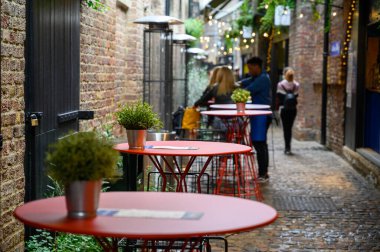 30 Eylül 2019 'da Camden Market' in açık hava yemek alanındaki kaldırımlı bir caddede bir sıra masa.