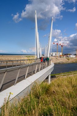 DUNKIRK, FRANCE - 13 AĞUSTOS 2019: Güneşli bir günde Dunkirk 'teki Passerelle du Grand Large Köprüsü' nden geçenler