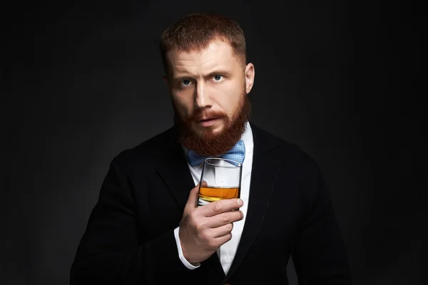 Elegante hombre barbudo guapo disfrutando del whisky — Foto de Stock