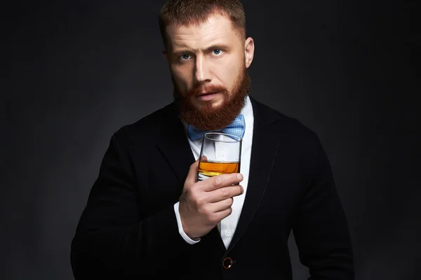 Stijlvolle knappe bebaarde man genieten van whisky — Stockfoto