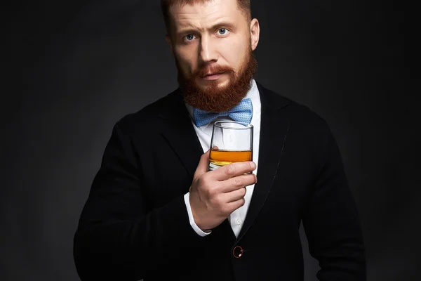 Elegante hombre barbudo guapo disfrutando del whisky — Foto de Stock