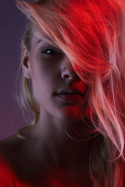 Blonde girl in red light — Stock Photo, Image