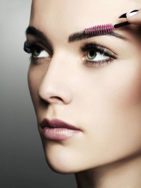 güzel bir genç kadın makyaj yapıyor