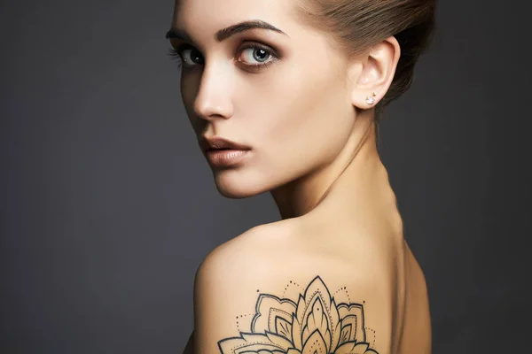 Mooie vrouw met tatoeage — Stockfoto