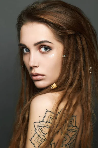 Mujer joven con tatuaje y rastas — Foto de Stock