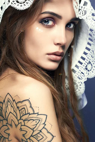 Ung kvinna med tatuering, dreadlocks och spets sjal — Stockfoto